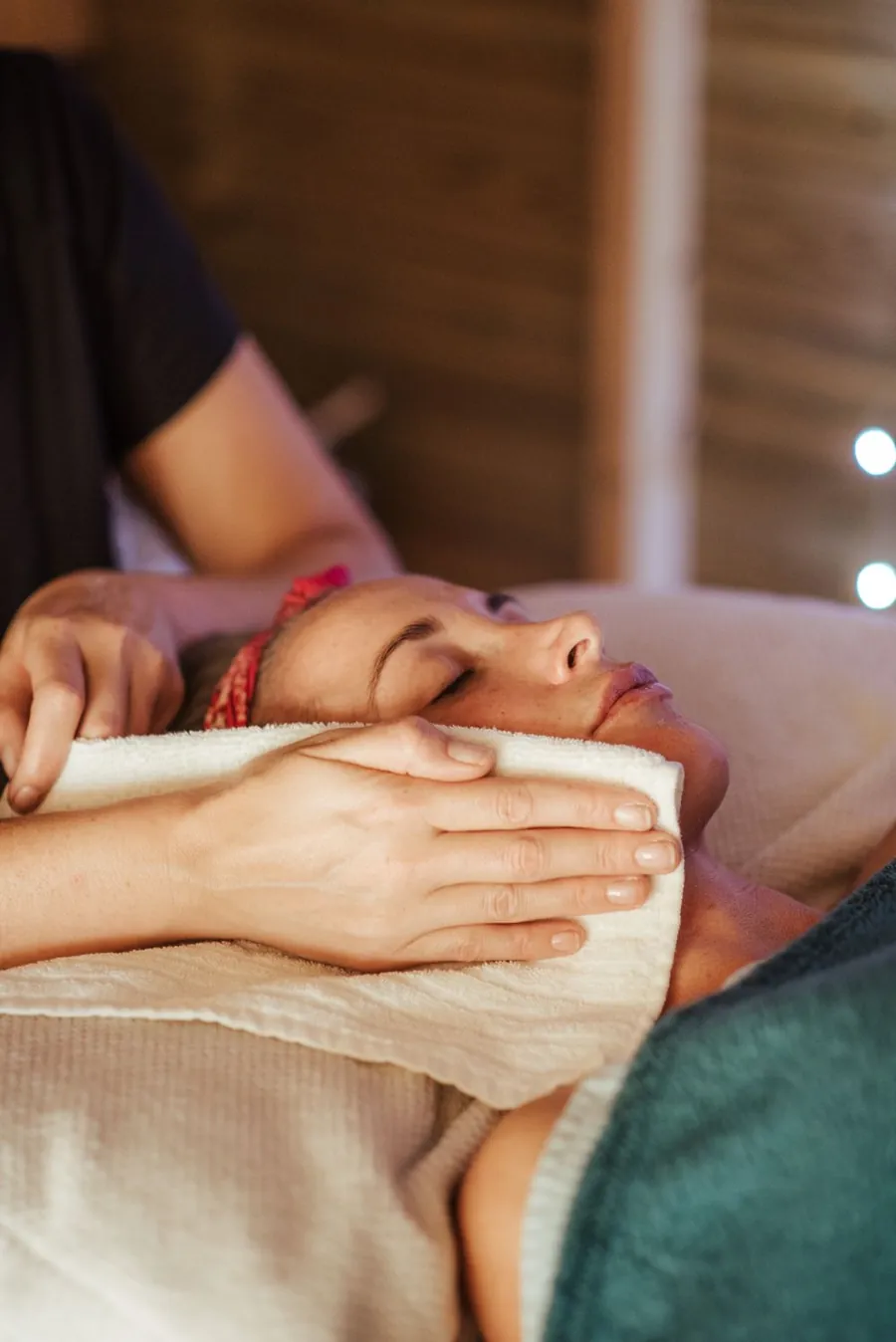 Mujer relajándose durante un ritual de spa con luz cálida